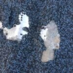 Sand falling from the coated metal roof tiles made of stone