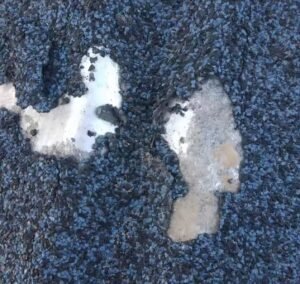 Sand falling from the coated metal roof tiles made of stone