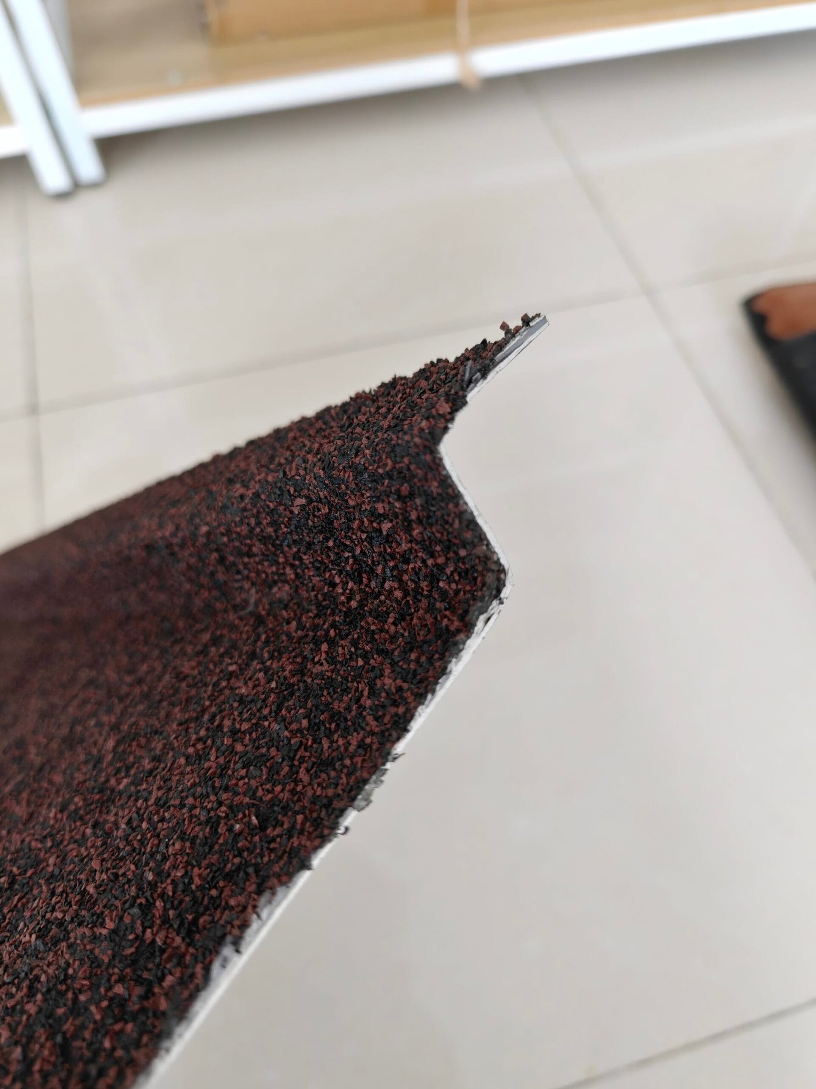 Poor quality tiles with rusted edges and exposed substrate